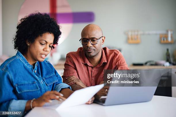 An African American couple reviewing their finances and investment plan together on a laptop